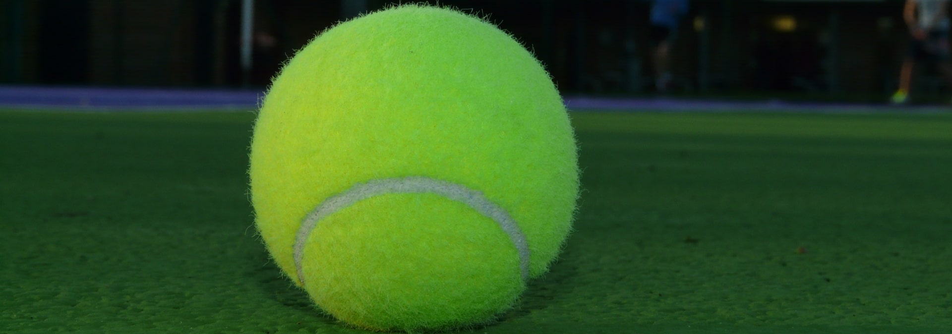 Tennis ball in the middle of court 8 with a blurred background to depict privacy